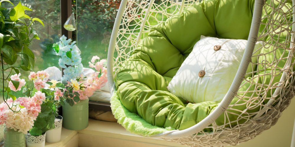 garden swing with mattress and cushion in a balcony in the morning